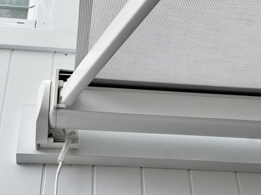 All white retractable motorised folding arm awning installed on the building facade over the courtyard in Subiaco, Perth WA